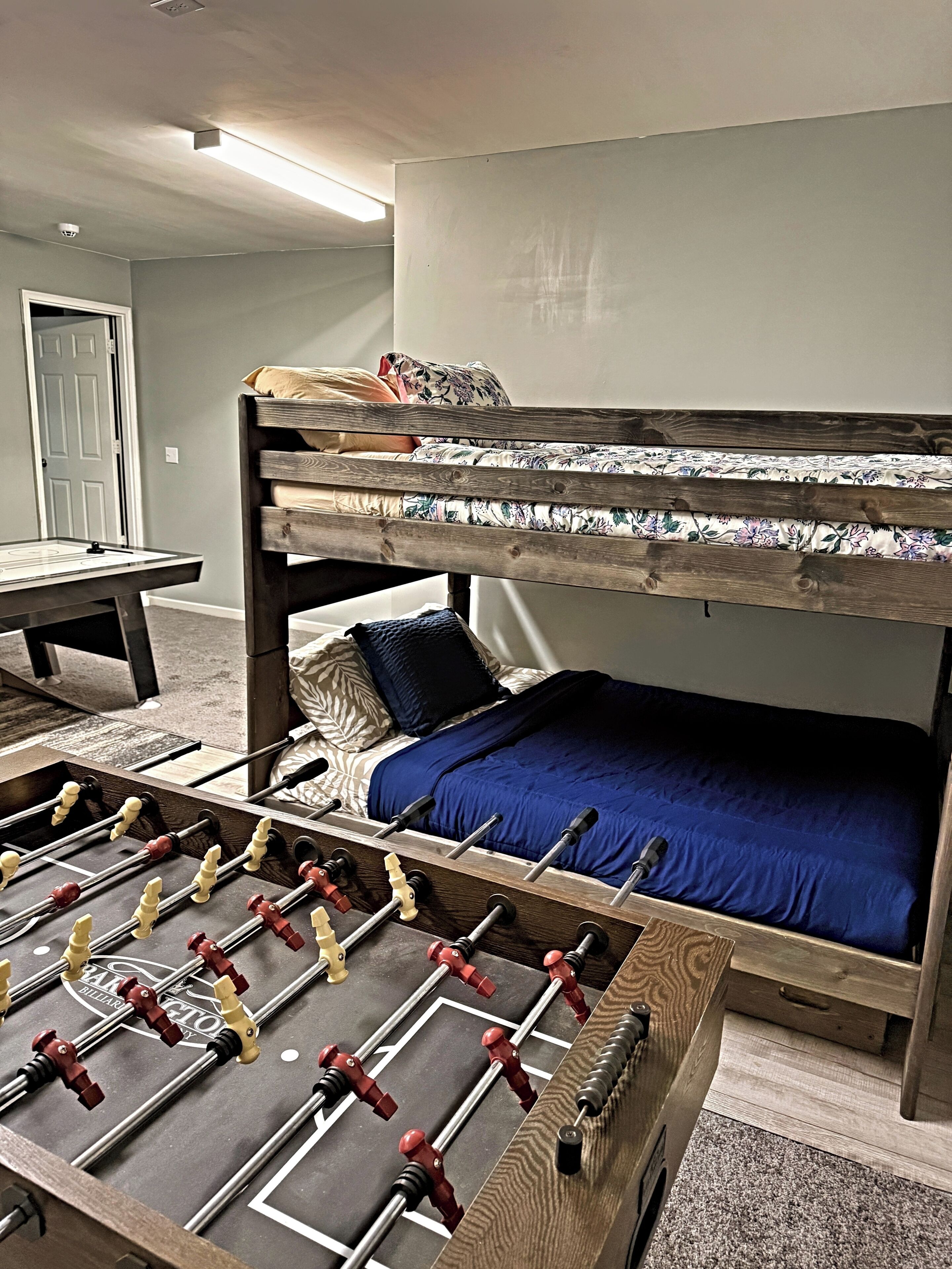 Una cama litera con una mesa de fútbol sobre un fondo.