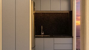 A modern kitchen with grey cabinets, a black countertop, and a marble floor. - Pousada Mar do Sul (Itapema)