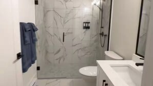 Ein modernes Badezimmer mit Dusche, Toilette und Waschtisch.