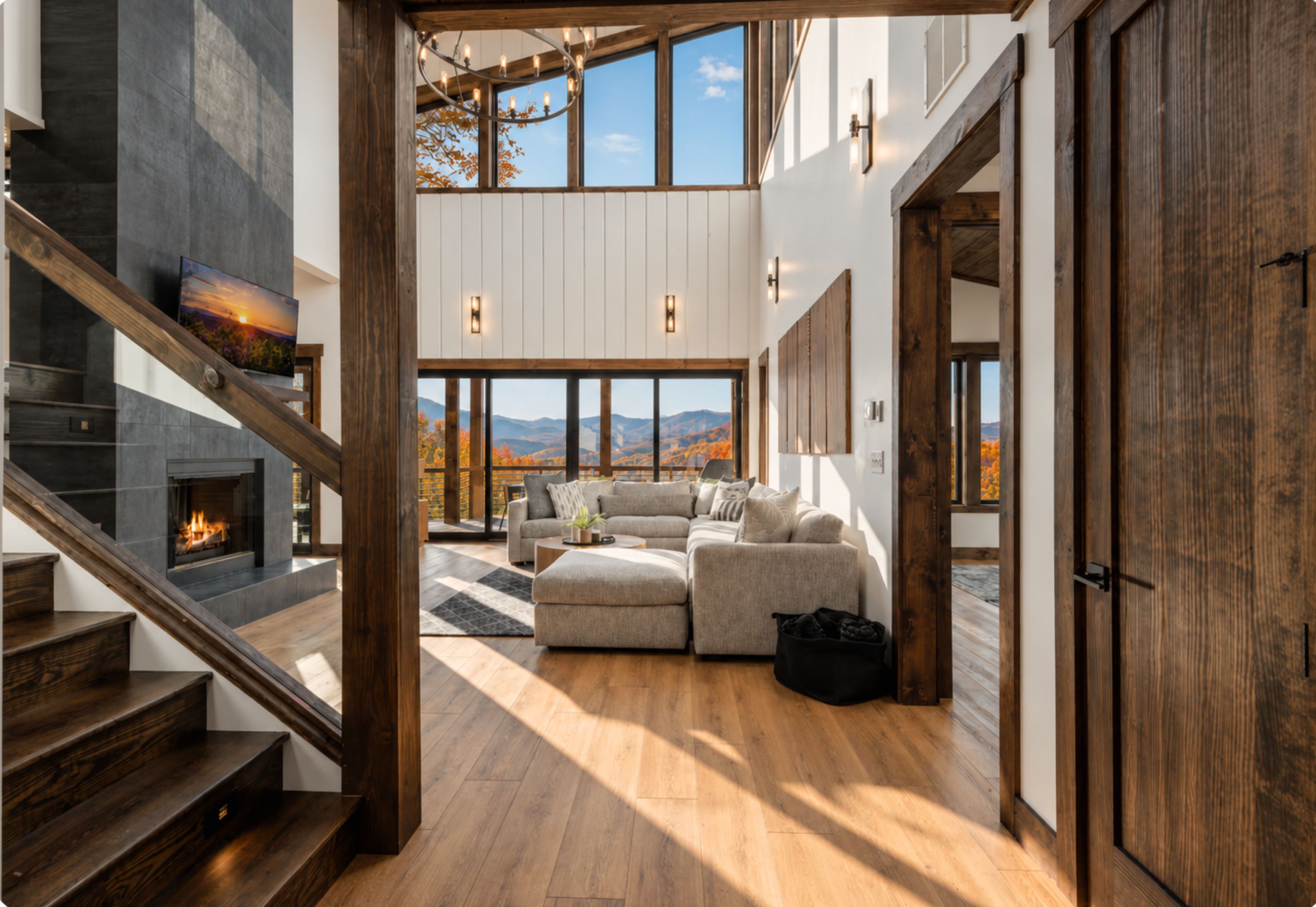 A spacious living area with a fireplace, a large sofa, and a view of the outdoors.