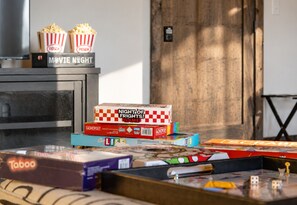 Une pièce avec une porte en bois, un téléviseur, des boîtes de pop-corn et divers jeux de société.