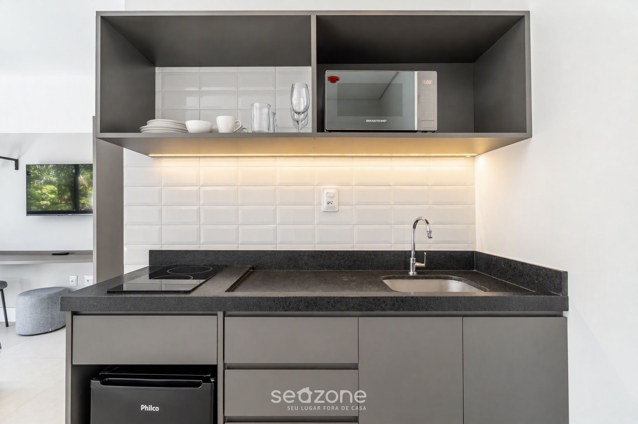A modern kitchen with a built-in microwave, a sink, and a dishwasher.