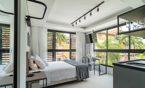 A modern hotel room with a bed, bedside table, lamp, and large windows offering a view of the outside. - Modern Studios 150m From Lagoa da Conceicao - Lsts I (Florianópolis)