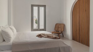 Ein schlicht eingerichtetes Schlafzimmer mit Bett, Stuhl und Wandpaneelen aus Holz.