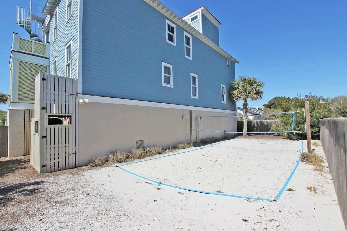 A blue building with a fenced tennis court.