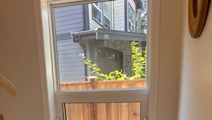 A staircase with wooden steps leading to a window with a view of a house and a fence.