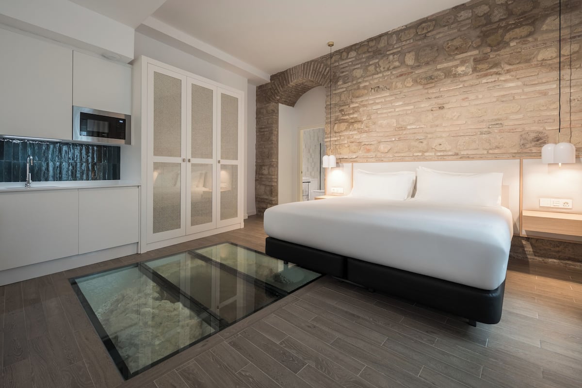 Copriletto in piuma, postazione laptop, tende oscuranti