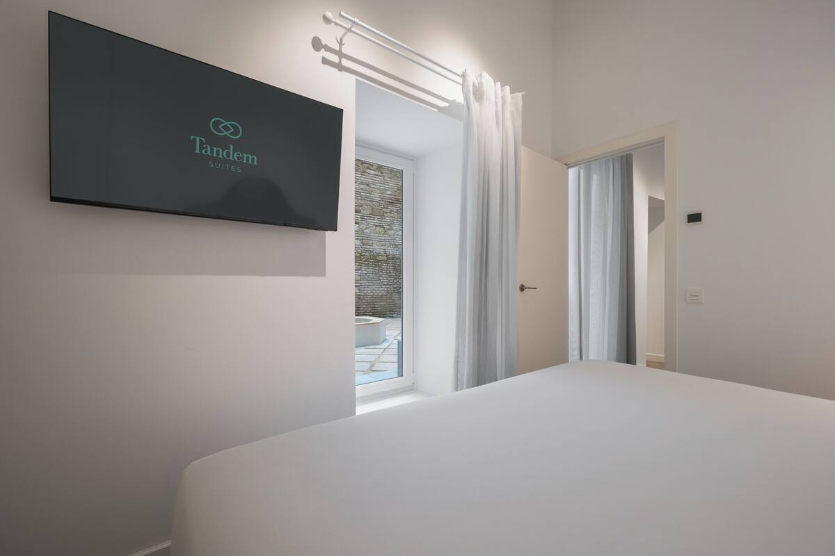 Copriletto in piuma, postazione laptop, tende oscuranti