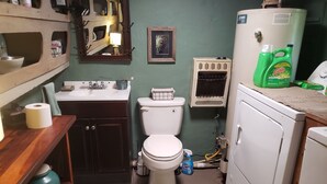Un bagno compatto con il water, lavandino e una lavatrice.