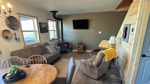 A cozy living room with a fireplace, a dining table, and comfortable seating. - Secluded Mountaineee -View Cabin with Hot Tub & Endless Country Sky (Elgin)