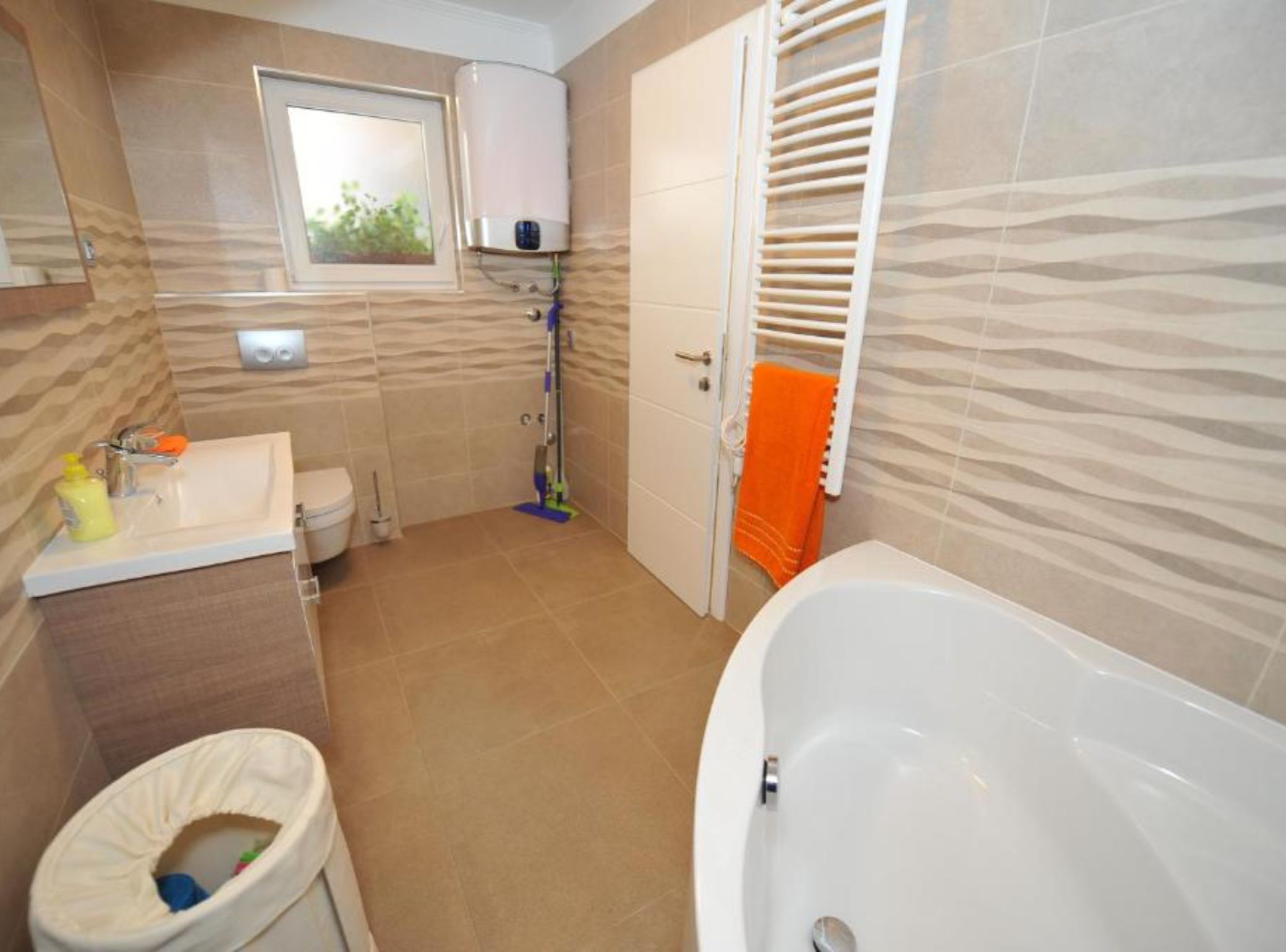 A bathroom with a bathtub, toilet, sink, and shower.