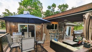 An outdoor patio with a grill, seating area, and a covered section with a TV. - Luxurious Littleton Living with Gourmet Kitchen, Huge Deck and Shared Backyard (Littleton)