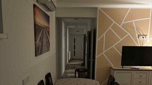 A hotel room with a dining area, a TV on a stand, and a hallway leading to the exit. - Comfort Apartment Luna (Varazdin)