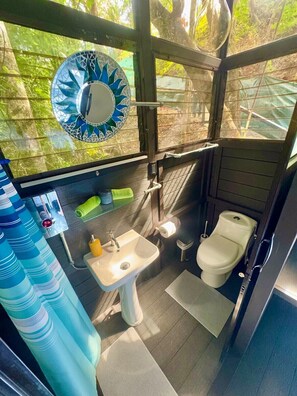 Ein kleines Badezimmer mit Waschbecken, Toilette und Spiegel.