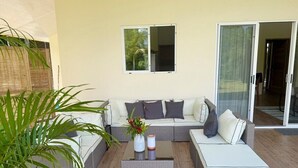 Una sala de estar moderna con un sofá modular, una mesa de centro y un ventanal de vidrio que da a un espacio exterior.