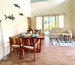 A dining area with a wooden table and chairs, a sofa, and a coffee table.