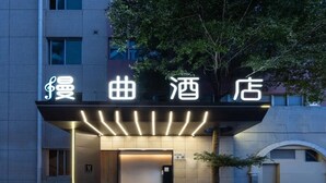 A hotel entrance with illuminated signage and a covered entrance area. - MANNSIC Hotel- Shenzhen Haishang Shijie (Shenzhen)