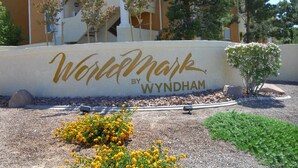 A sign with "WorldMark by Wyndham" written on it, surrounded by landscaping and a building in the background. - Worldmark Tropicana for NFR Rodeo & WSTR (Las Vegas)