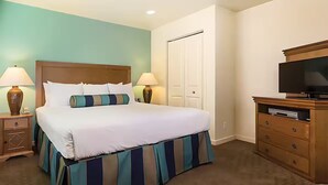 A hotel room with a large bed, two bedside lamps, a TV on a wooden cabinet, and a wardrobe. - Worldmark Tropicana for NFR Rodeo & WSTR (Las Vegas)