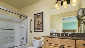 A bathroom with a shower, toilet, vanity, and a framed artwork on the wall. - Worldmark Tropicana for NFR Rodeo & WSTR (Las Vegas)