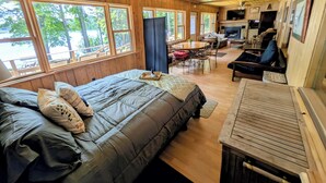 A wooden cabin with a bed, a dining table, and a fireplace. - Secluded 8 acre lakefront resort on Grand Portage Lake. (Mercer)