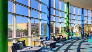 A spacious indoor area with large windows, outdoor seating, and a patterned floor. - Splash! Kids Aqua park, Free rental chairs! (Panama City Beach)