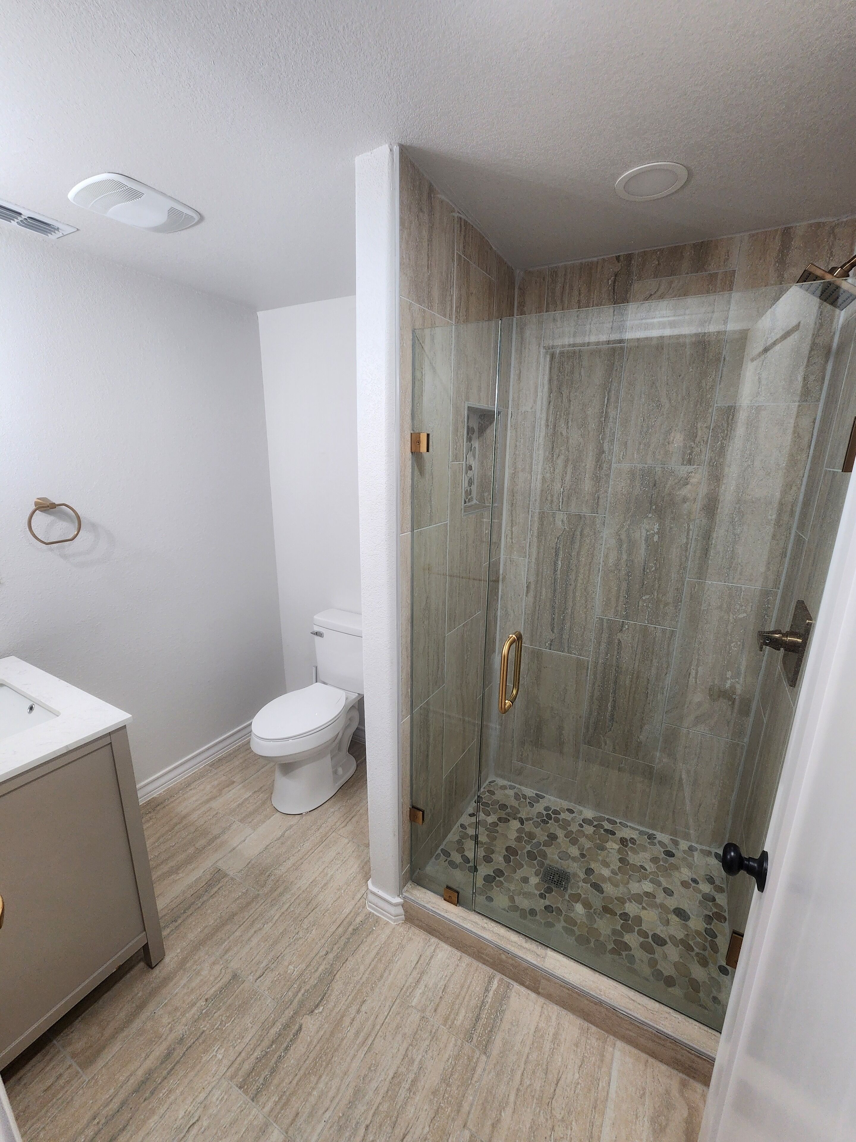 Ein Badezimmer mit Duschkabine, Toilette und Waschbecken.