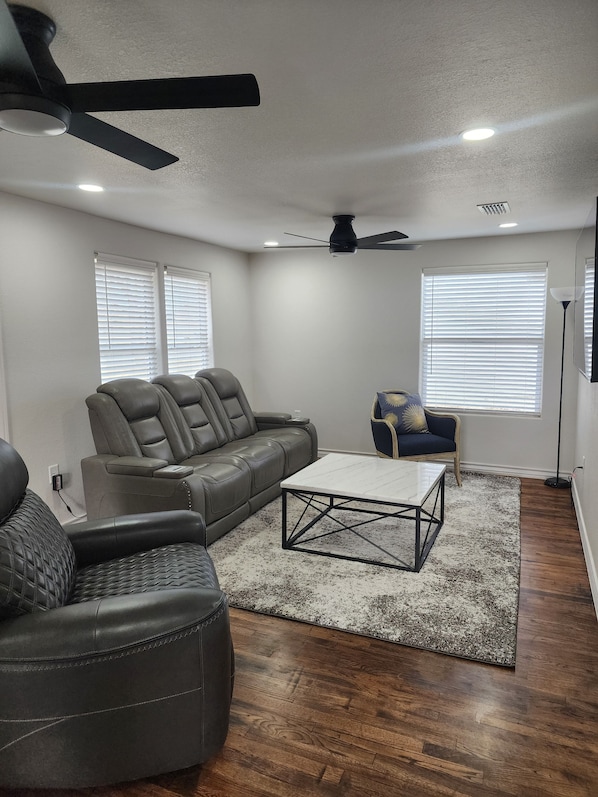 A living room with a sectional sofa, ottoman, and a coffee table.