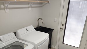 A laundry room with two white washing machines, a black sink, and a door with a window. - Passing through/visiting family/doing business &need your own space? Stay Here! (Breckenridge)