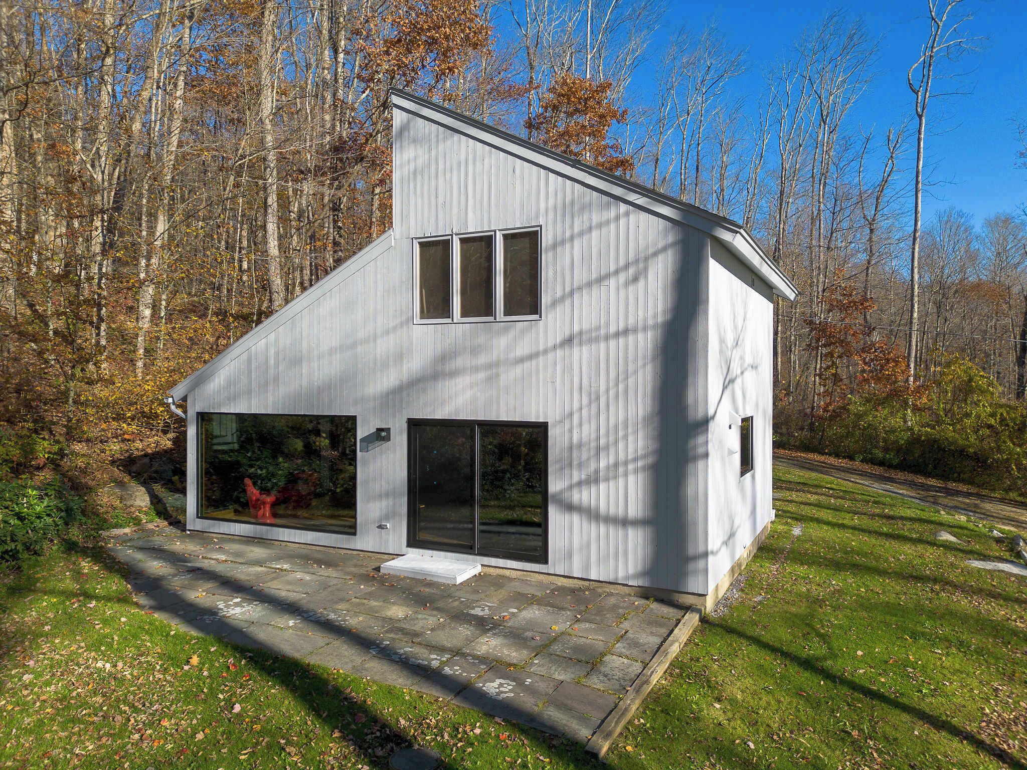 A modern, single-story house with a sloped roof, large windows, and a garage.