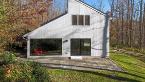 Una casa moderna con un garaje amplio y un patio cubierto.