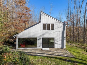 Una casa moderna con un garaje amplio y un patio cubierto.
