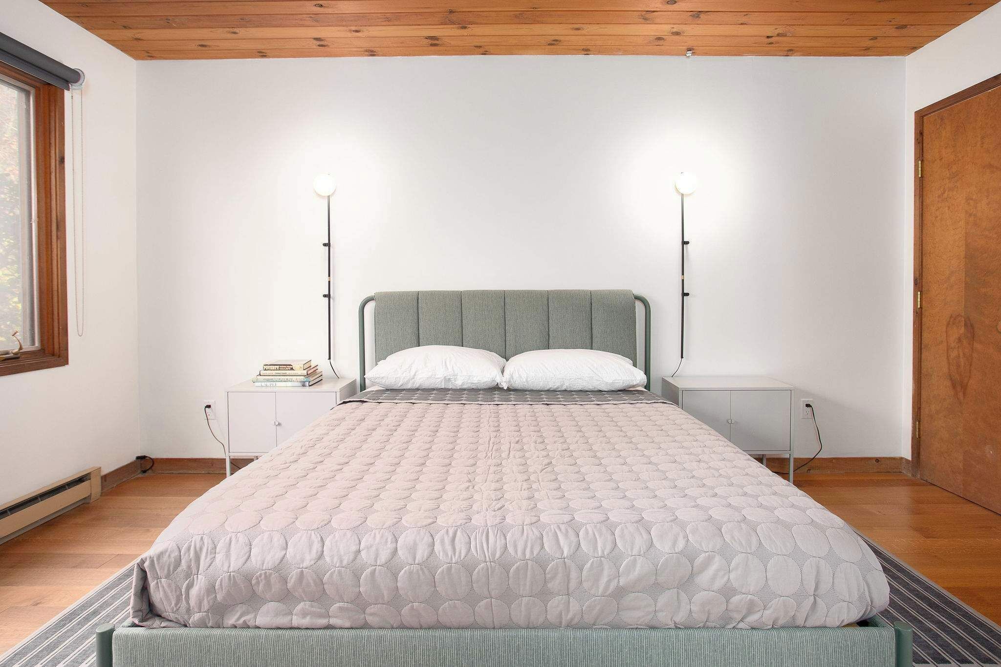 Ein Schlafzimmer mit einem Bett, zwei Nachttischen und einem Beistelltisch.