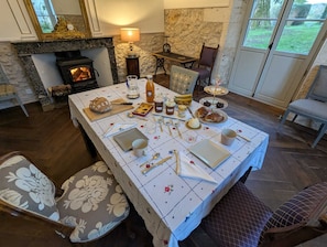 Uma sala de jantar com mesa posta para refeição, lareira e vista para o exterior.