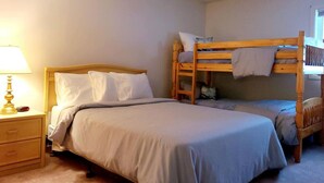 Ein Schlafzimmer mit einem Einzelbett, einem Nachttisch und einem Etagenbett.
