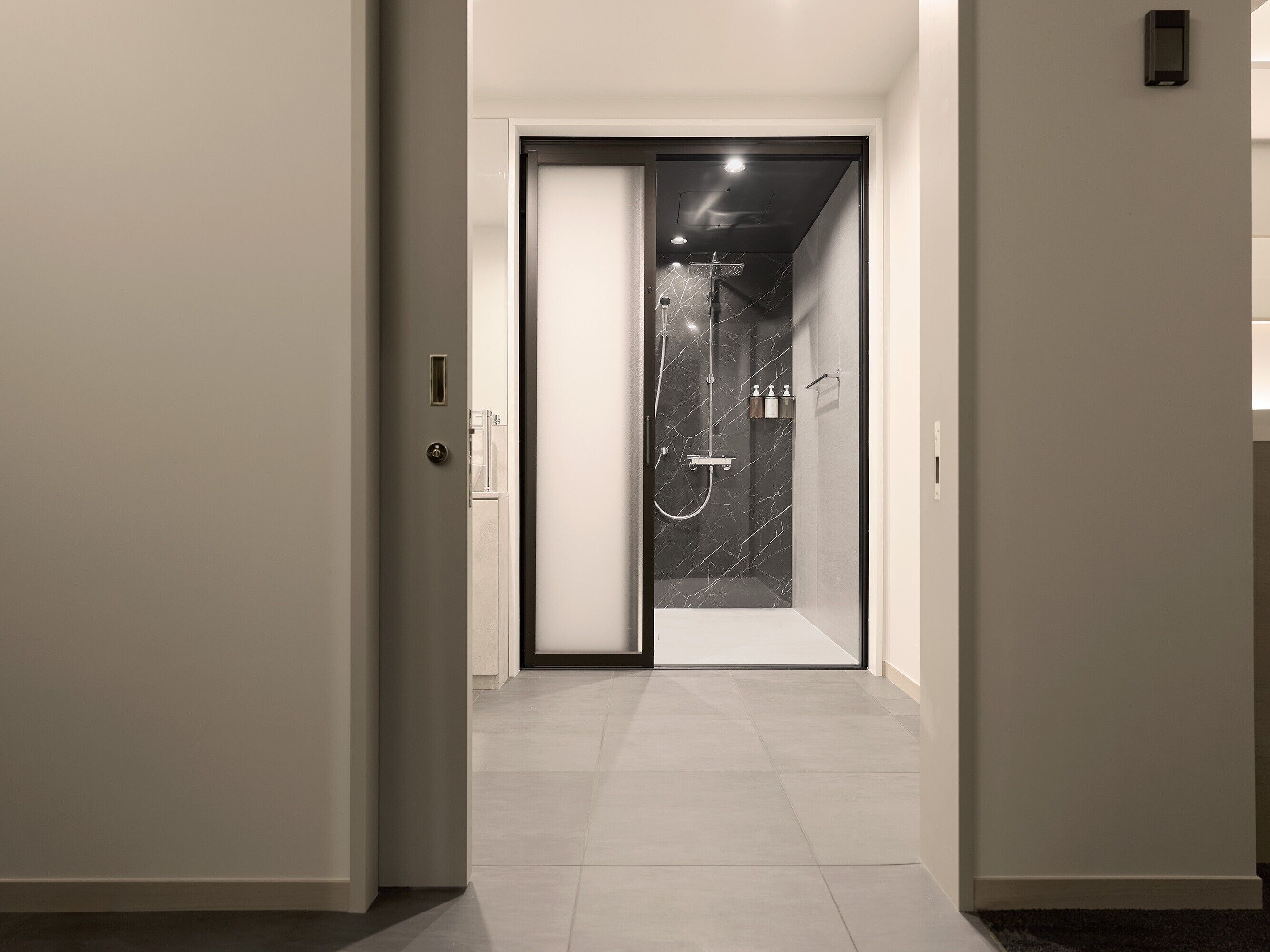 A modern bathroom with a glass shower enclosure, a toilet, and a sink.
