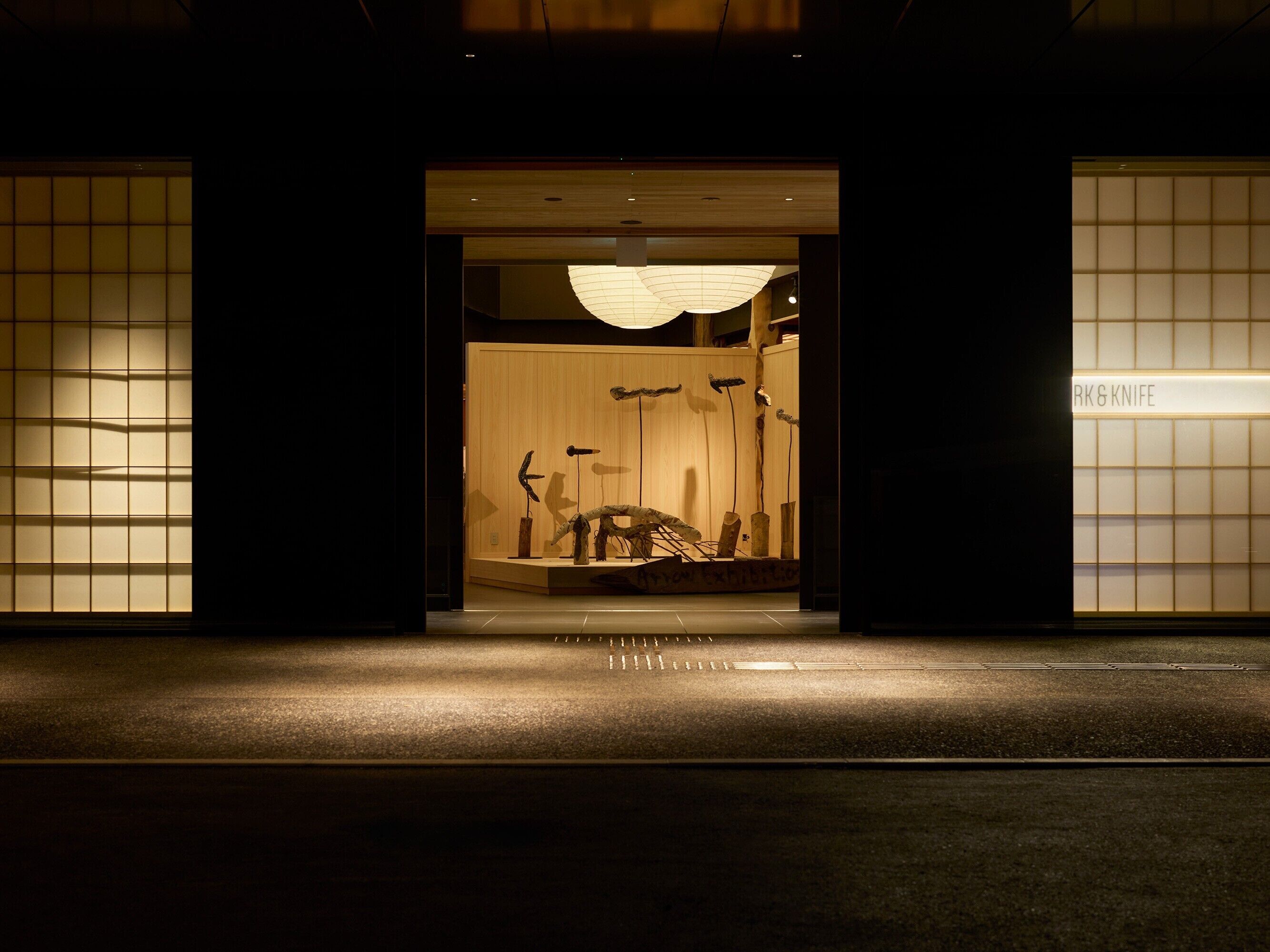 A building entrance with a wooden door and a sign reading 'RKG & KNIFE'.