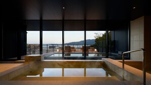 A modern indoor pool area with a view of the sea and mountains. - HOTEL FORK & KNIFE Miyajima (Hatsukaichi)