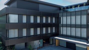 A modern building with multiple floors, large windows, and a flat roof.