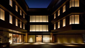 A hotel with a central courtyard, multiple floors, and traditional-style windows. - HOTEL FORK & KNIFE Miyajima (Hatsukaichi)