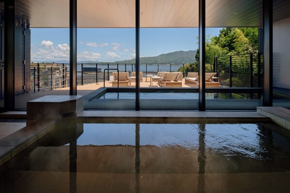 A pool area with a view of the sea and mountains.