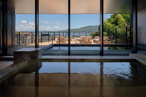 A pool area with a view of the sea and mountains.