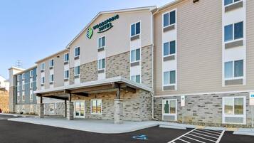 A multi-story hotel with a stone facade, a covered entrance, and a parking lot with handicapped accessibility.