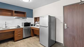 Una cocina moderna con armarios de madera, un refrigerador de acero inoxidable, un microondas y un lavavajillas.