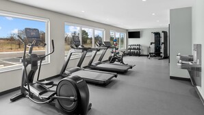 Een moderne sportschool met loopbanden, elliptische trainers en gewichthefapparatuur.