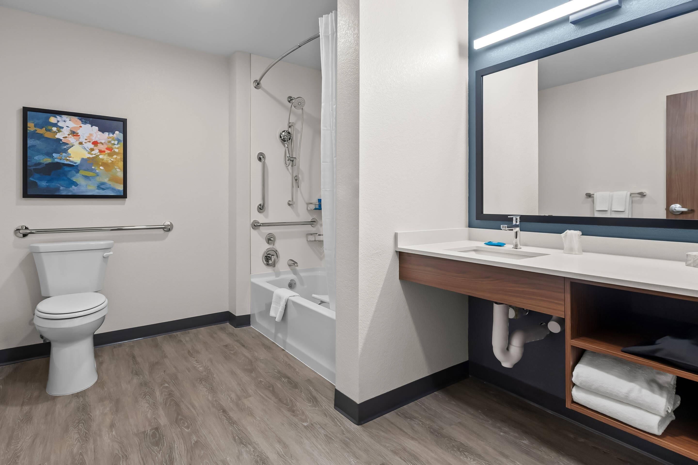 A modern bathroom with a toilet, shower, and sink.