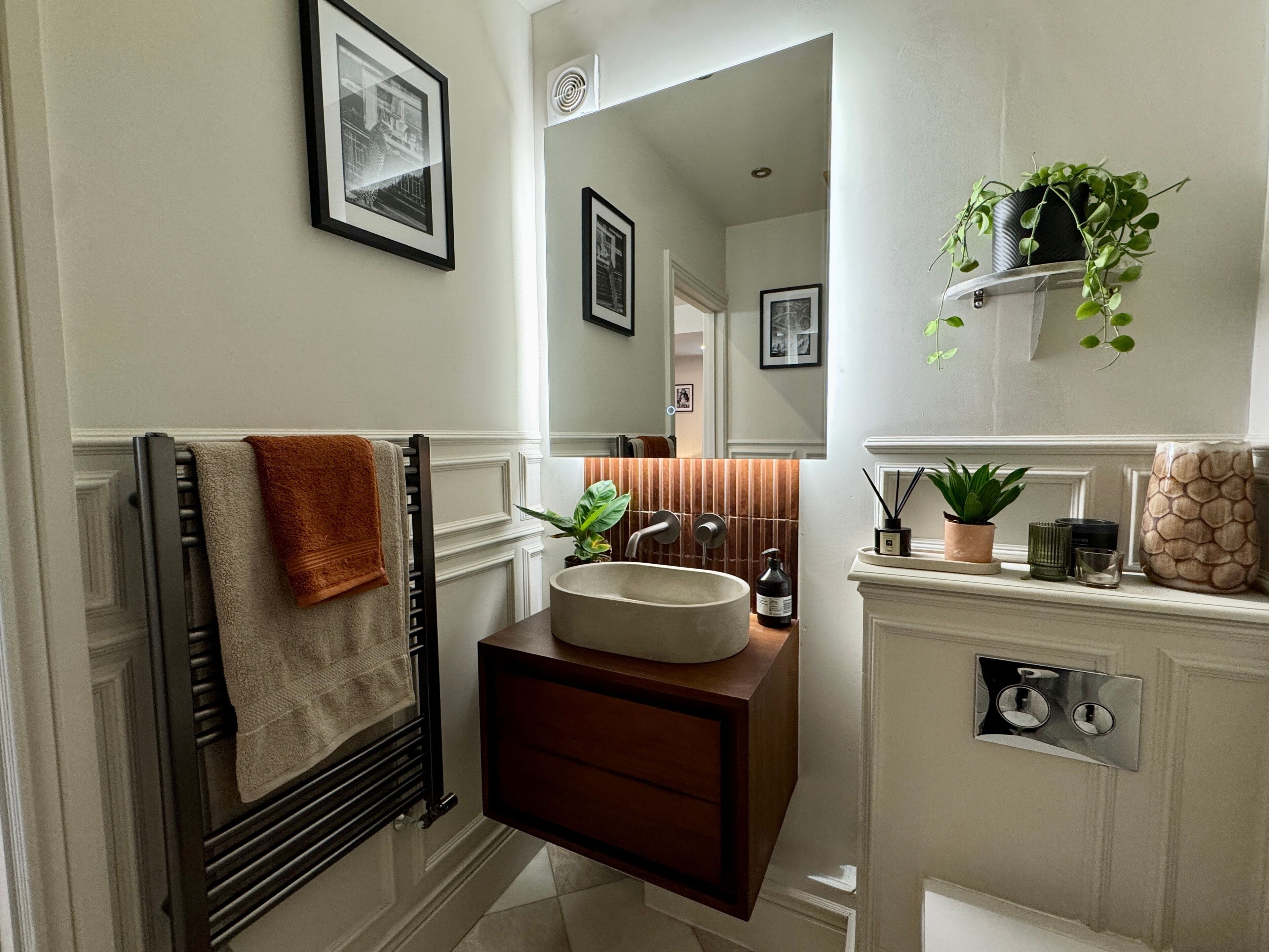 A bathroom with a vanity, towel rack, and a mirror.