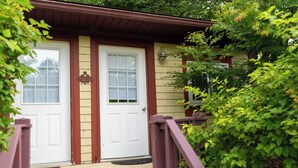 Et hus med en veranda, to døre og en lille trappe op til indgangen.