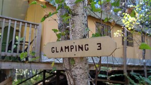 Un letrero en un árbol que dice 'GLAMPING 3'.