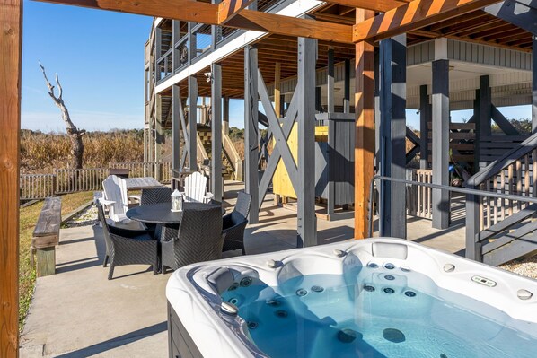 A hot tub with a wooden deck and outdoor seating area. - Steps to Beach! Spacious 5BR, Hot Tub, Kayak, BBQ, Sleeps 12 (North Topsail Beach)